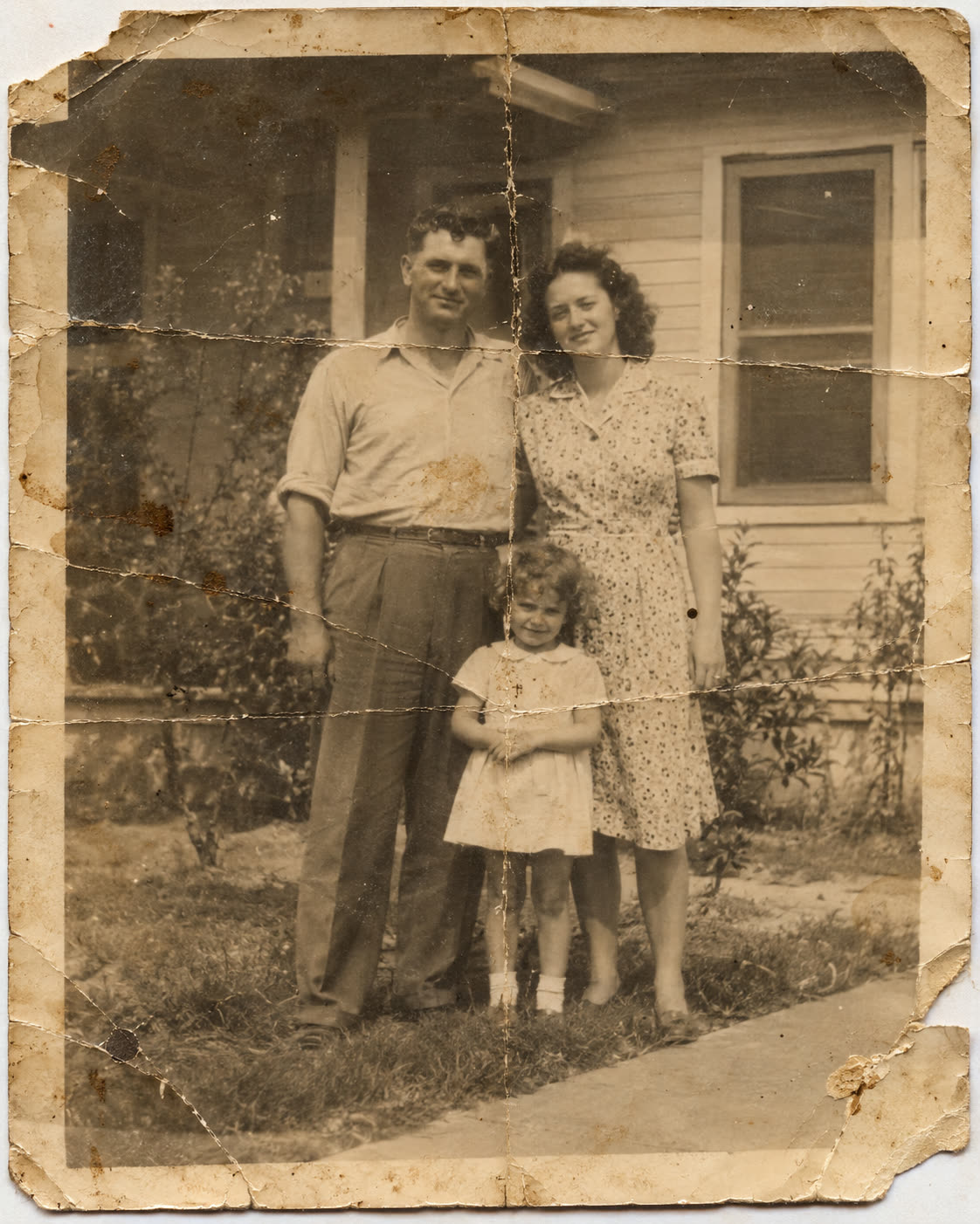 A faded, scratched black-and-white family photo — before